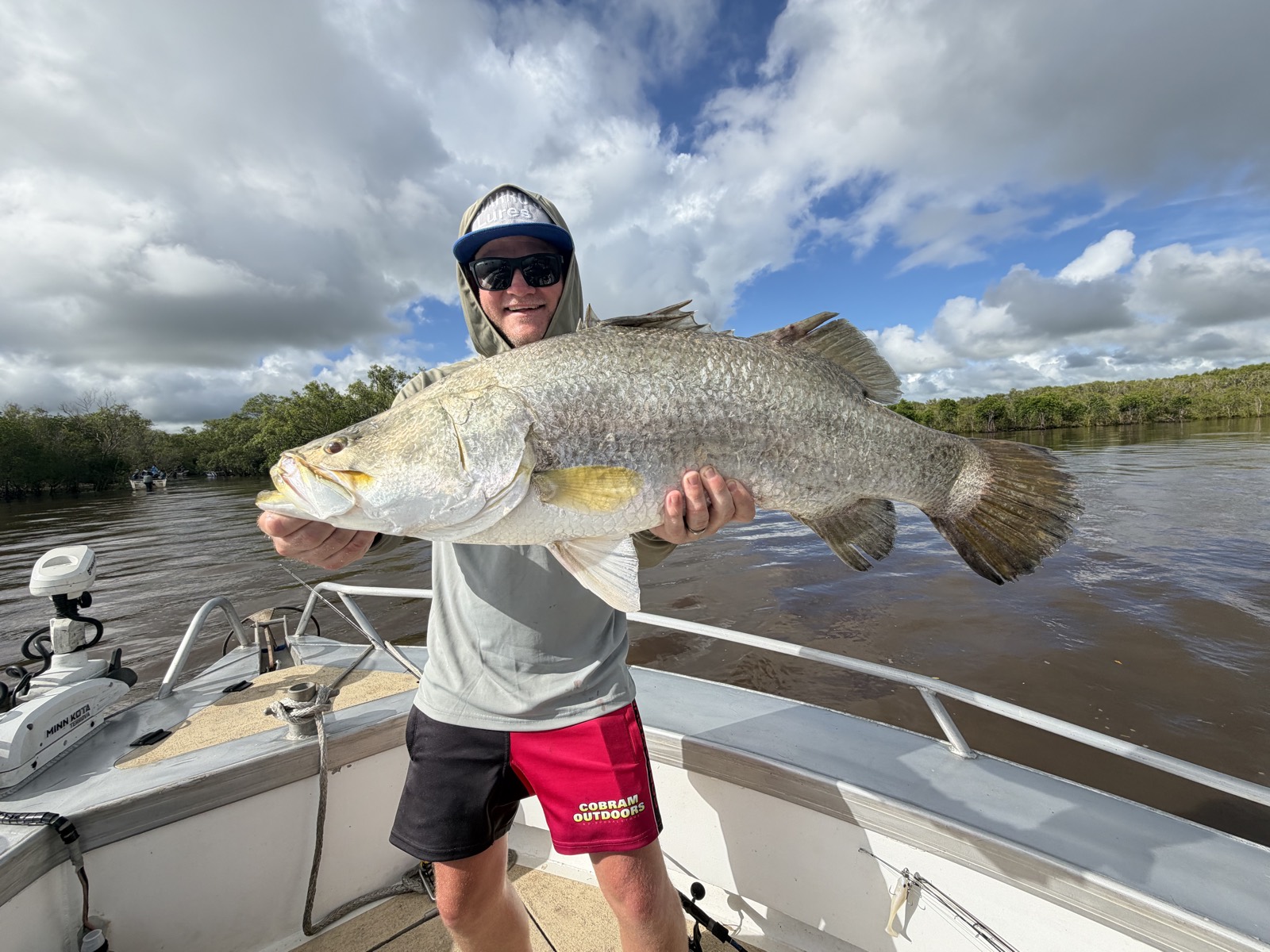 Young angler holding a chrome barramundi on a Top End run-off barra charter near Darwin