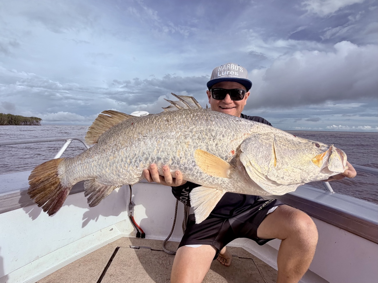Angler holding a big silver barramundi on a Cape Adieu Top End barra charter