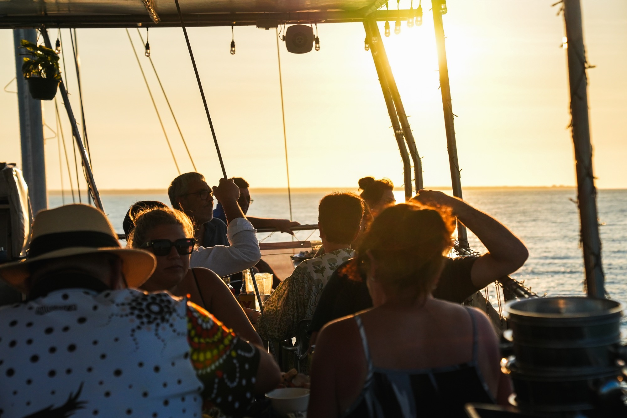 Guests relaxing on deck at golden hour on Darwin Harbour