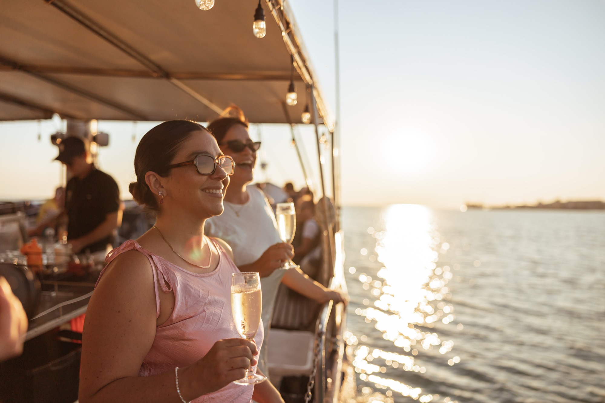 Guest with a glass of champagne watching the Darwin Harbour sunset