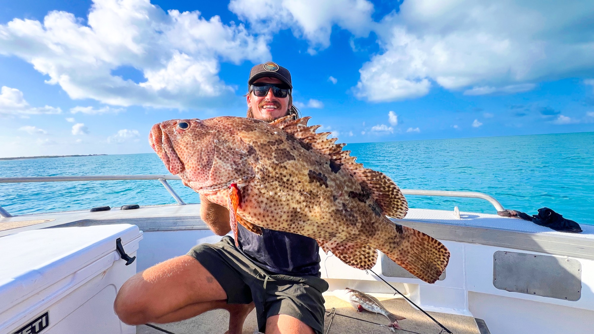 Angler holding an estuary cod caught on an offshore Darwin fishing charter