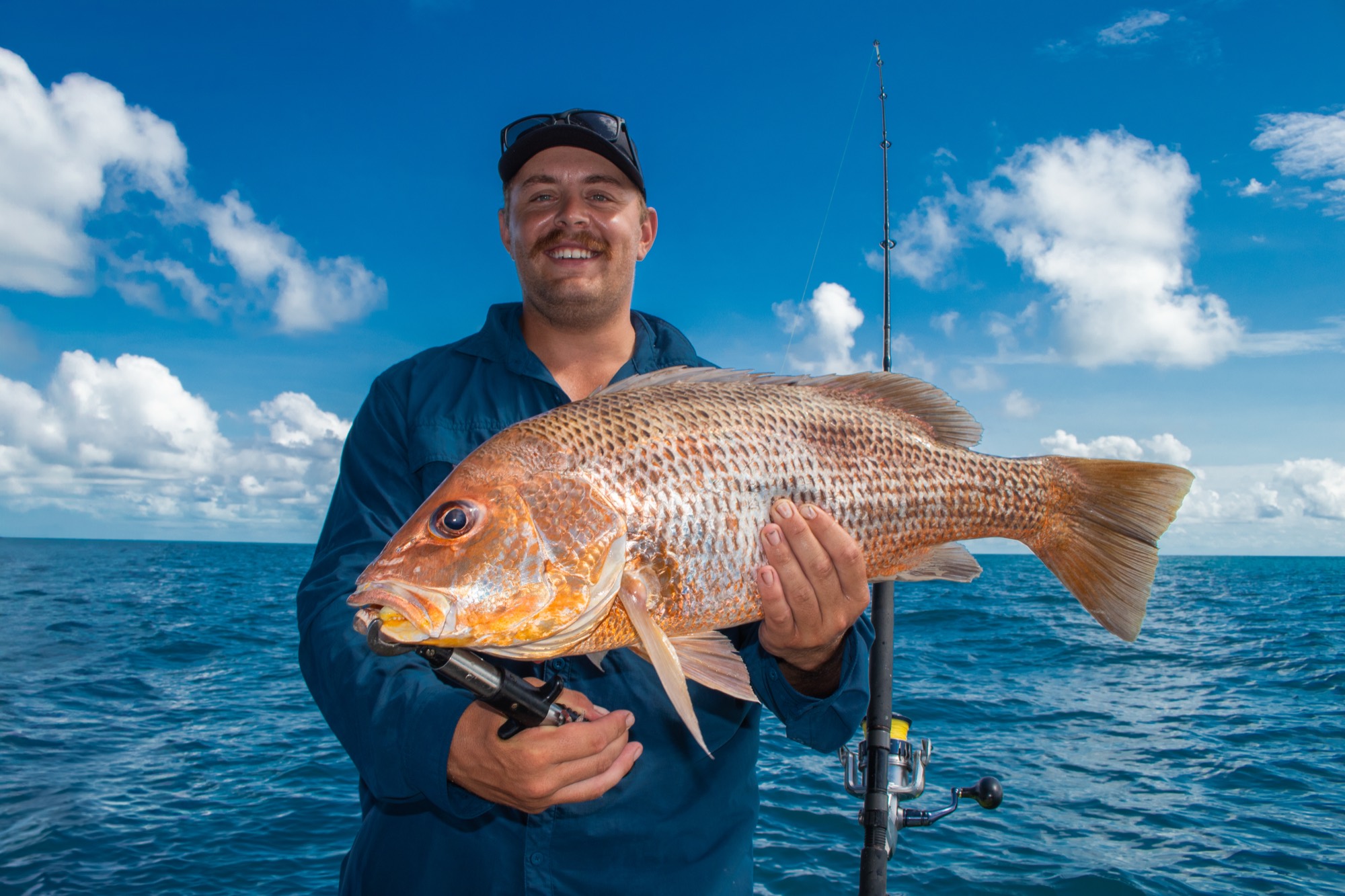 Angler with a golden snapper caught on a Darwin Harbour fishing charter