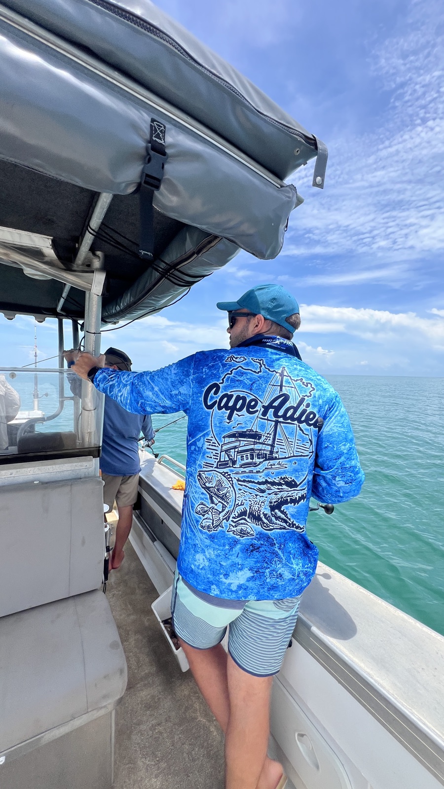 Crew member in a Cape Adieu shirt fishing on a Darwin Harbour charter