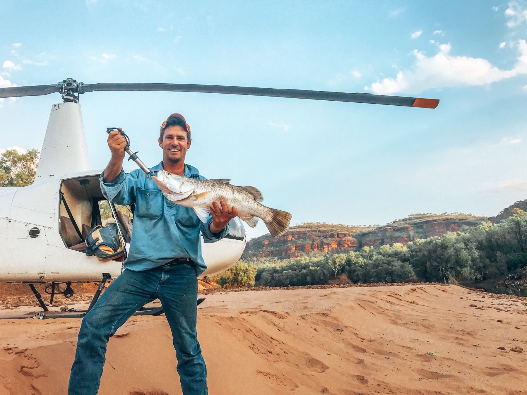 A barramundi held up on a remote West Arnhem Land coastline during a Cape Adieu fishing safari